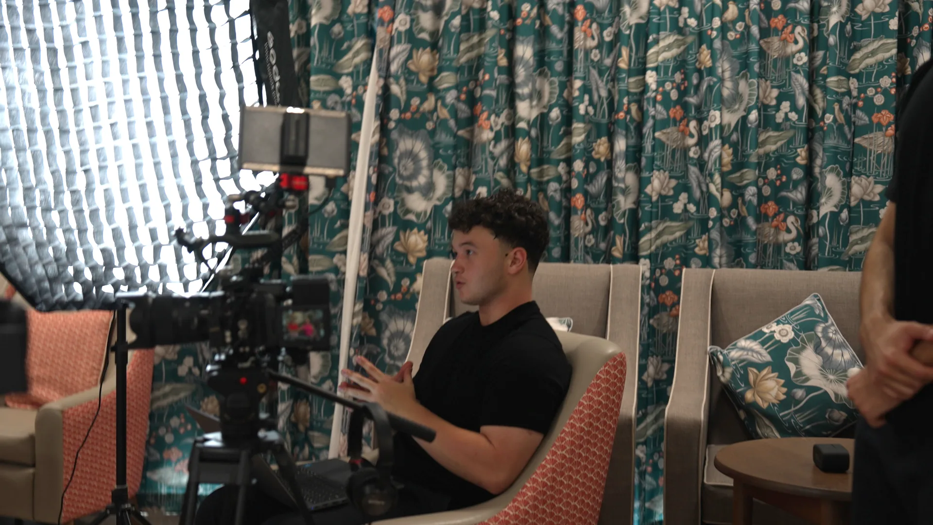 A family interview being filmed quietly in a care home lounge.