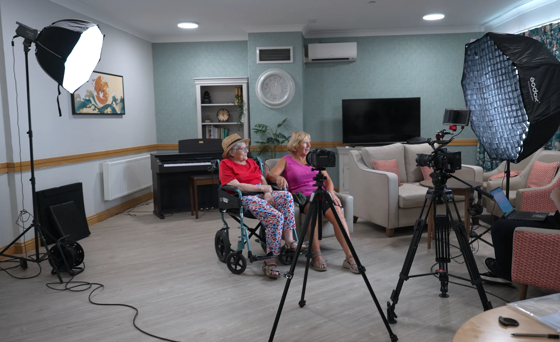 An interview being lit and set up in a care home lounge.