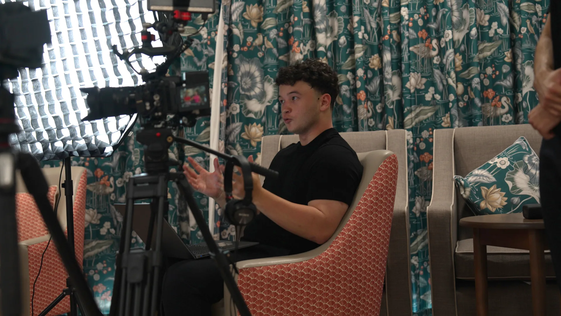 A videographer setting up to film an interview inside a care home.