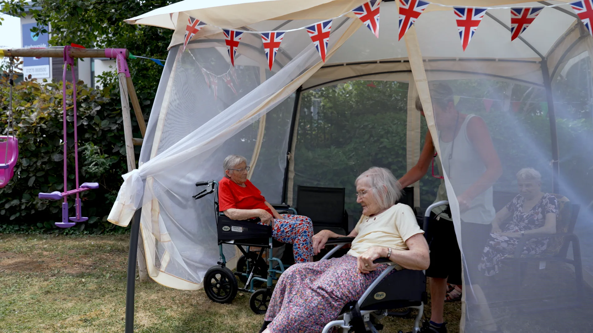 Residents relaxing together in a garden gazebo.